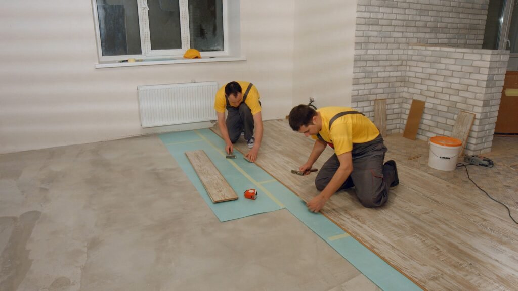 Builders laying wooden flooring.